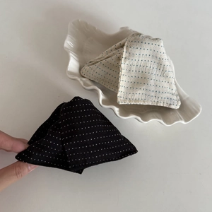Eleganti mollette per capelli in raso a pois neri e crema su piatto decorativo a conchiglia