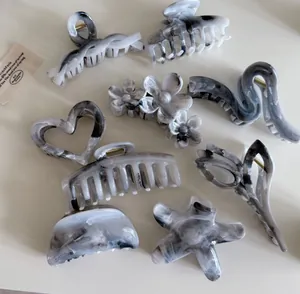Vue détaillée de pinces à cheveux à texture marbrée grise aux motifs floraux élégants