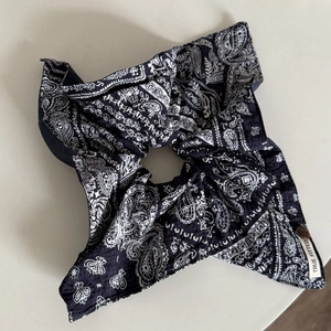 Détail d'un chouchou bleu marine à motif paisley avec étiquette cousue sur textile léger