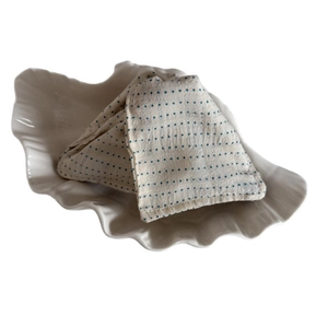 Elegante pinza per capelli in raso beige a pois blu su un vassoio a conchiglia