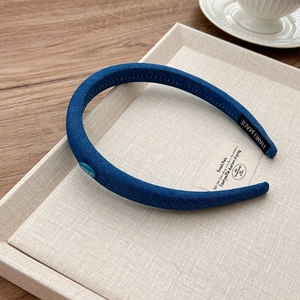 Detail shot of navy denim headband with visible fabric texture and handmade label
