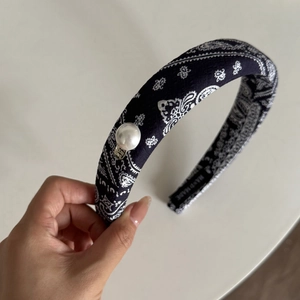 Détail du serre-tête bandana bleu marine avec perle blanche et marquage fait main