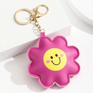Détail d'un porte-clés fleur en cuir PU rose avec visage souriant et fermoir doré chic