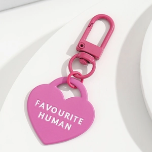 Portachiavi a cuore rosa con scritta Favourite Human su sfondo geometrico bianco