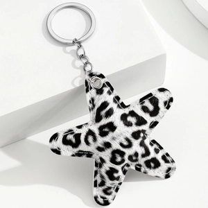Star-shaped keychain accessory in leopard print faux leather with silver metal hardware