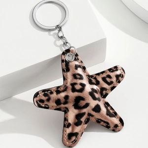 Detail showing the leopard print star-shaped keychain with silver metal ring and chain