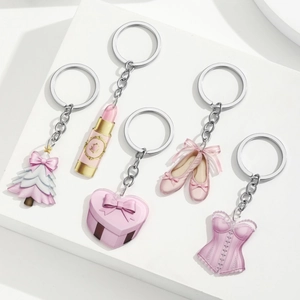 Pink acrylic Christmas charms set with tree, lipstick, and ballet shoes on white stand