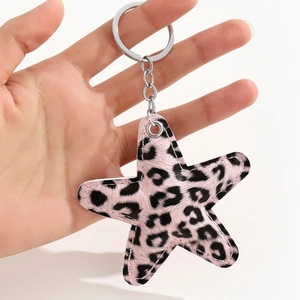 Close-up of pink leopard print star charm with silver metal ring and stitching detail