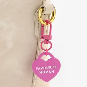 Portachiavi a cuore rosa con scritta Favourite Human attaccato a borsa beige