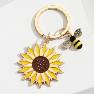 Porte-clés tournesol en alliage doré avec breloque abeille en strass sur fond blanc