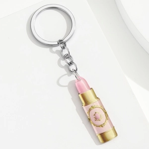 Detail view of a lipstick-shaped acrylic pendant with pink and gold decorative patterns