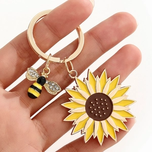 Gros plan du porte-clés tournesol avec breloque abeille en émail et cristaux scintillants