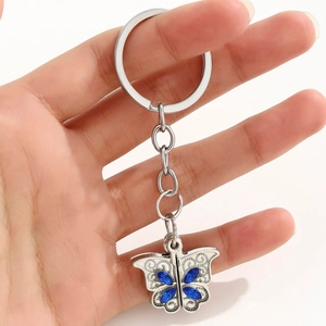 Gros plan d'un porte-clés papillon avec strass bleus et détails en métal évidé