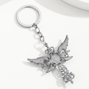 Détail du porte-clés croix ailes de démon en argent avec des motifs gothiques