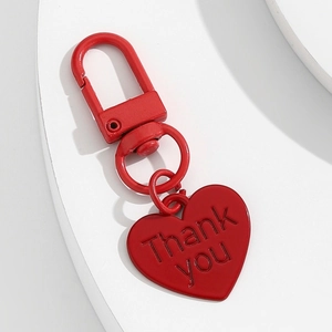 Porte-clés cœur rouge avec message Thank You gravé sur un support blanc minimaliste