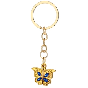 Porte-clés papillon doré avec gemmes bleues et détails filigranes sur fond blanc pur