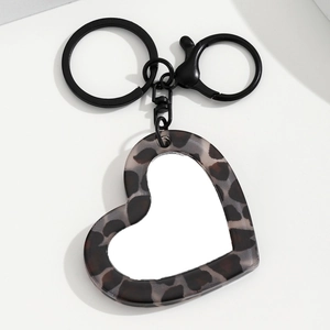 Detailopname van hartvormige sleutelhanger met luipaardprint en zwarte metalen ring