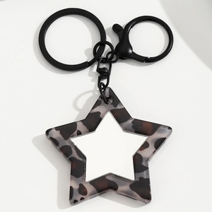 Detail van luipaardprint ster-sleutelhanger met zwarte metalen karabijnsluiting