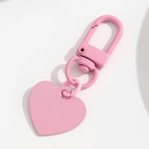 Détail du porte-clés cœur rose avec finition laquée mate et mousqueton pour accessoires