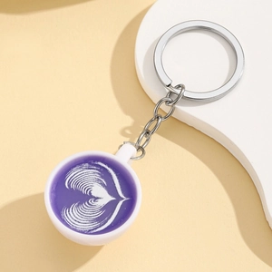 Macro shot of miniature coffee cup keychain with detailed white heart latte art