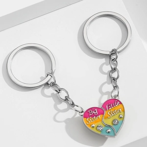 Détail de porte-clés puzzle cœur avec gravure Big Sister et Little Sister et strass brillants