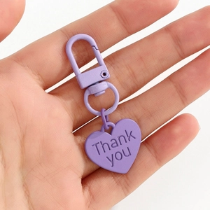 Détail d'un porte-clés cœur violet mat avec texte Thank You gravé sur métal