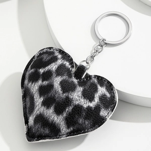 Detailed close-up of heart-shaped leopard print leather keychain with silver metal ring