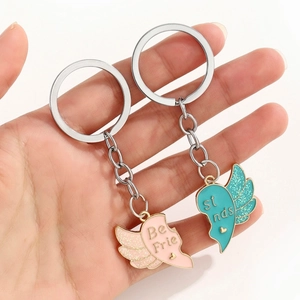 Vue détaillée des porte-clés ailes à paillettes rose et bleu avec texte Best Friends