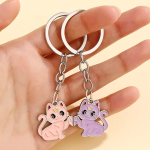 Détail des porte-clés chat couronne rose et violet formant un motif de coeur