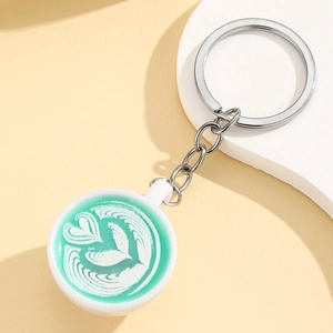 Luminous miniature coffee cup keychain with mint green latte art and heart pattern