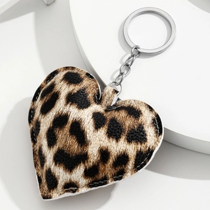 Heart-shaped leopard print keychain with silver metal ring on a white pedestal