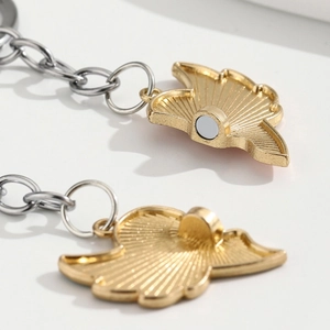 Détail macro de pendentifs cœur magnétiques dorés avec texture radiale pour couples