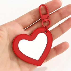 Detail view of the red heart-shaped mirror pendant with a functional mini makeup mirror