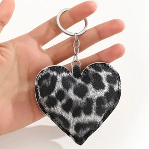 Faux leather leopard print heart keychain with silver metal ring held in hand