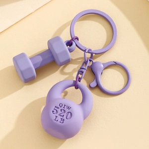 Detailed view of purple fitness keychain featuring textured kettlebell and dumbbell charms