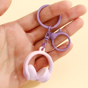 Detailed close-up of a pink-purple gradient headphone keychain held in hand