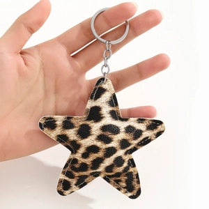 Detail of star-shaped leopard print keychain with white stitching and silver metal ring