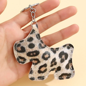 Détail d'un porte-clés chien à motif léopard avec coutures blanches et anneau en métal