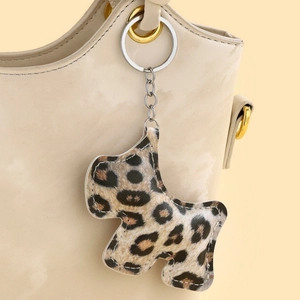 Porte-clés chien à motif léopard sur un sac à main en cuir beige élégant