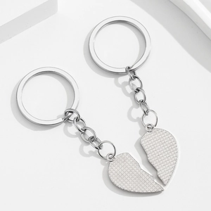 Silver metal heart shaped best friend keychains with textured finish on white steps