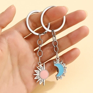 Detailed shot of pink sun and blue moon keychains with silver metal and white rhinestones