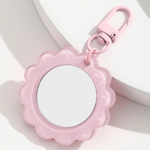 Close-up of pink flower-shaped portable mirror keychain with metallic d-ring hook