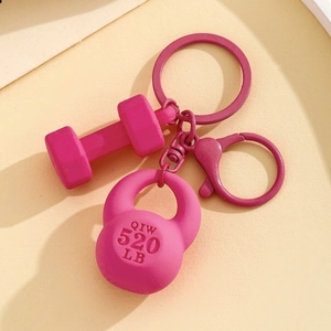 Detailed macro view of vibrant rose red dumbbell and kettlebell keychain charms