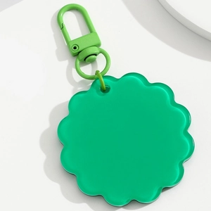 Detailed macro of green petal-shaped acrylic sunflower pendant with matching metal clip