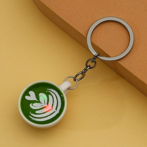 Detailed close-up of a creative matcha latte art coffee cup keychain with silver ring
