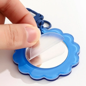Blue sunflower shaped pocket mirror with acrylic wavy edge and blue plastic keychain hook