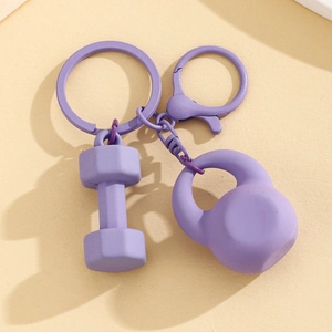 Macro detail of matte purple alloy dumbbell and kettlebell keychain set with lobster clasp