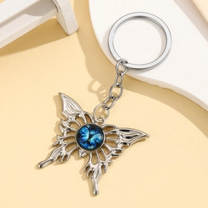 Gothic hollow butterfly keychain with blue devil eye pendant on minimalist background