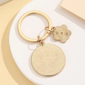 Detailed view of polished gold alloy keychain with blank round tag and floral charm