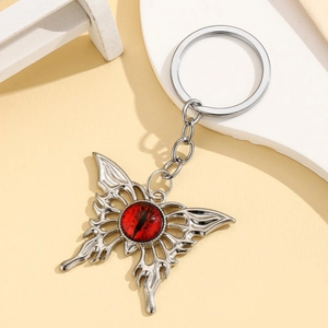 Macro shot of gothic butterfly keychain with a red evil eye and silver hollow wings